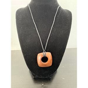 Square wood like brown necklace pendant with black fabric cord. 16 in. fashion